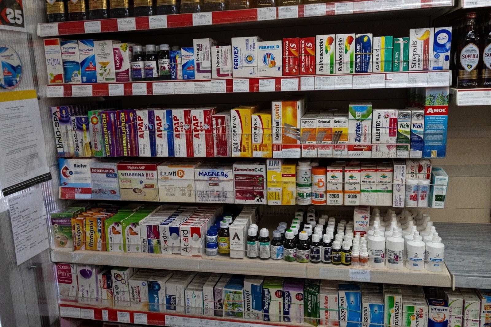 Polish pharmacy shelf with cold and flu remedies, painkillers and vitamins