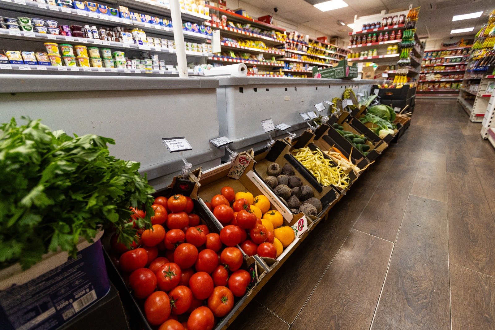 Fresh fruit and vegetables on display down the shop aisle 1